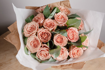 capuchino grade roses. Florist girl with rich bunch flowers. Fresh spring bouquet. Summer Background. Young woman flower for birthday or mother's day.