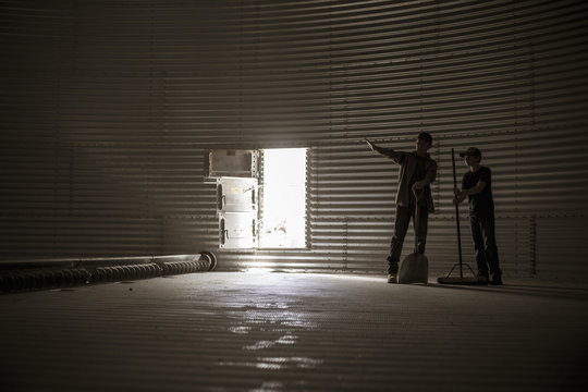 Father and son standing in empty silo