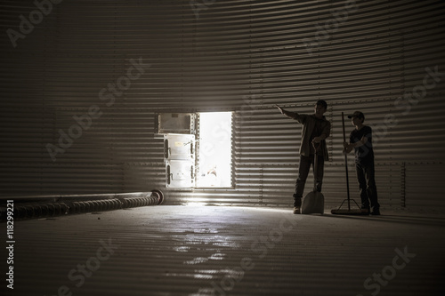 Father And Son Standing In Empty Silo Stockfotos Und