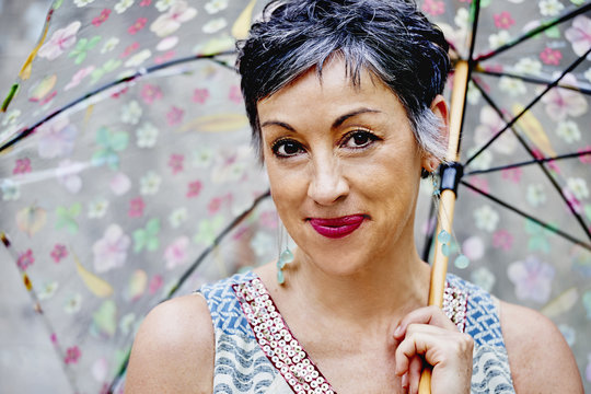 Older Caucasian woman posing with umbrella