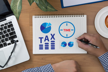 TAX TIME   Business team hands at work with financial reports
