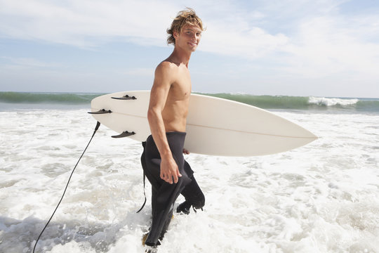 Caucasian surfer carrying surfboard
