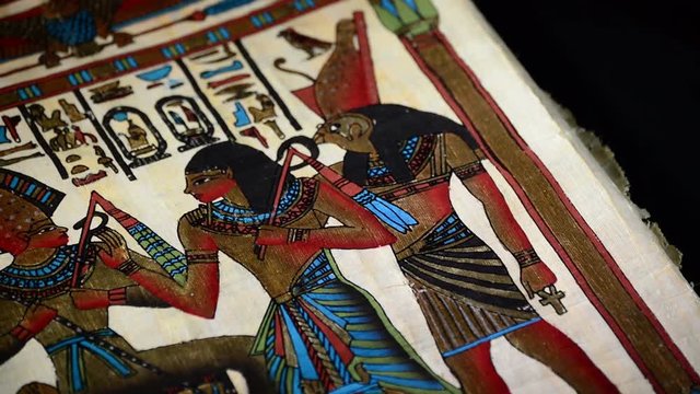 Egyptian papyrus with pharaohs and hieroglyphics representation of turning on black background