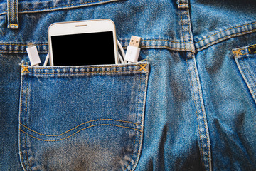 White smartphone in your pocket blue jeans with USB cable for transfer data or information on isolated background. copy space