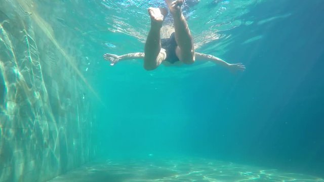 Man Swimming Underwater in Swimming Pool. Slow Motion.