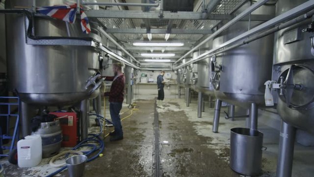  Workers in a brewery cleaning & checking the machines
