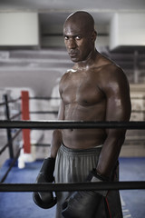 Intense African boxer standing in boxing ring