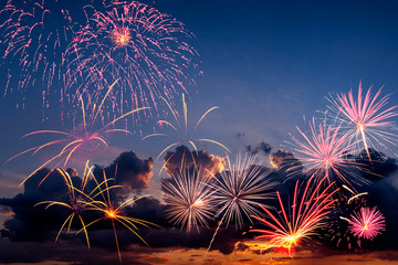 Holiday fireworks in the evening sky with majestic clouds, long exposure