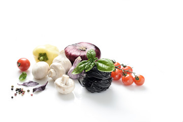 black pasta and fresh basil, mushrooms, cherry tomatoes, onions, peppers on a white background