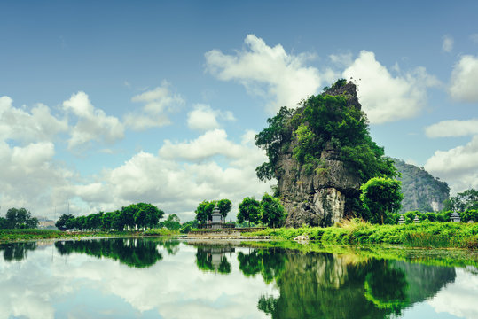 Beautiful natural karst tower reflected in water. Toned image