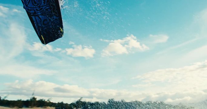 Beautiful young woman kiteboarding at sunset in slow motion, active lifestyle extreme sport