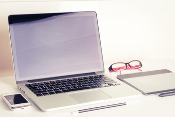 Fototapeta premium Office desk with laptop smart phone and business office backgrou