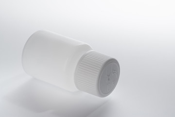 White plastic medical container bottle, on gray background