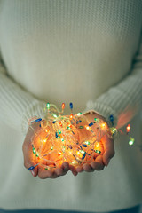 Female hands holding glowing lights: festivity and celebrations