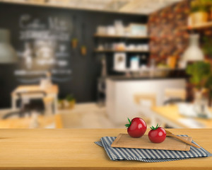 wooden counter top with tomato and chopping board on kitchen cabinet background