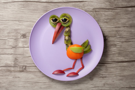 Heron made of fruits on plate and desk