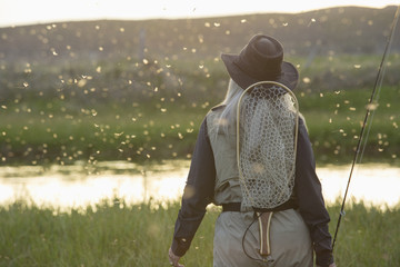 Caucasian woman wearing fishing gear in remote lake