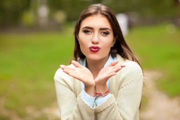 Beautiful girl sends a kiss and looking at the camera