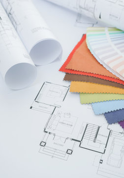 Architectural drawing with color palette , fabric sample and a roll of paper