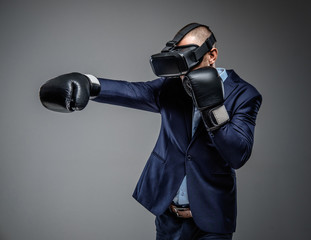 Male in a suit fighting with virtual reality glasses on his head