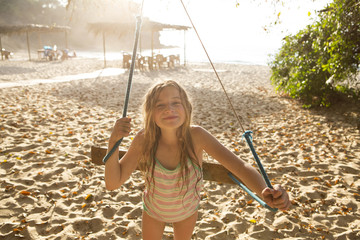 Portrait of girl playing on tree swing