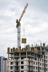 Fototapeta na wymiar Construction of multi-storey buildings with Crane. Workers work