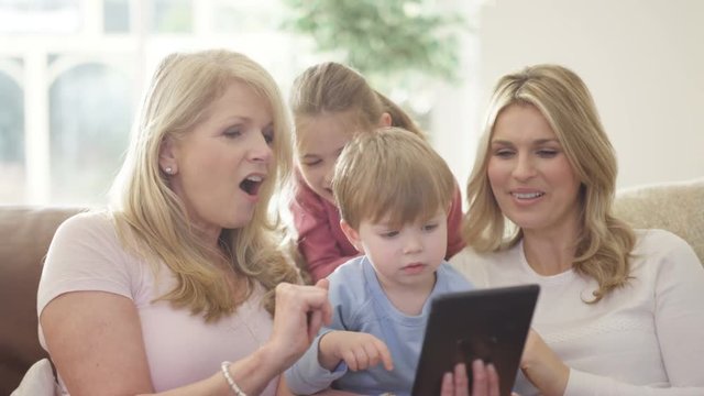  3 Generations of happy family making video call on tablet computer
