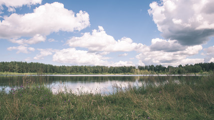 Dark storm clouds over meadow with green grass - vintage effect