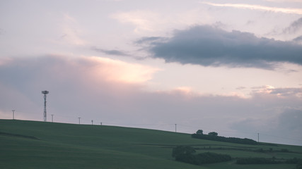 Fototapeta na wymiar Dark storm clouds over meadow with green grass - vintage effect