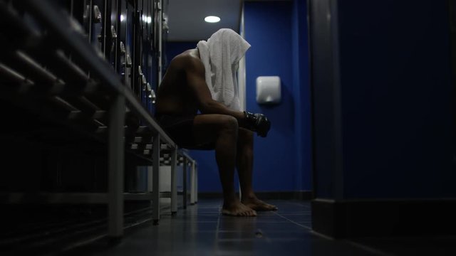  MMA fighter sits alone in locker room, psyching himself up before a fight