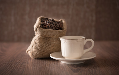 Antique porcelain cup and coffee bag on wooden