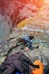 Hiker photographer climbs on the cliff in Alps. Switzerland, Trek near Matterhorn mount.