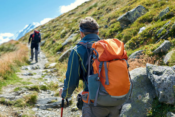 hikers with backpacks on the trail in the Apls mountains. Trek near Matterhorn mount