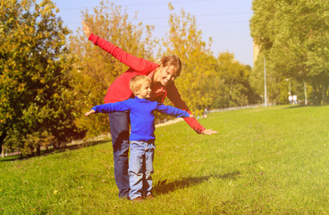 mother and son play in autumn nature
