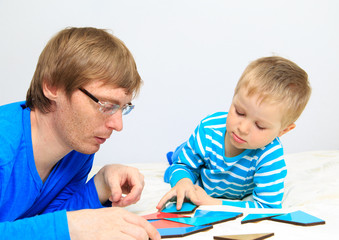 father and son playing with puzzle, early education