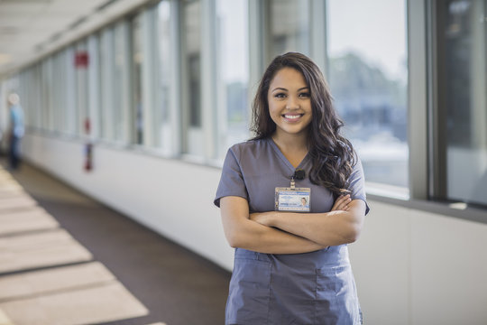 Mixed race nurse smiling in hospital hallway