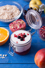 Jar of fruity yoghurt on a blue wooden table