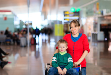 mother and little son on trolley in the airport