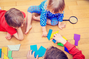 teacher and kids playing with geometric shapes, early learning