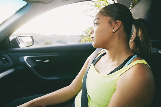 Mixed Race woman daydreaming in car
