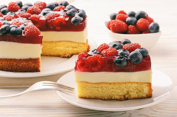 Piece of delicious cheesecake with berry jelly and berries.