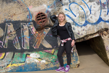 Beautiful blond girl posing in front of graffiti wall