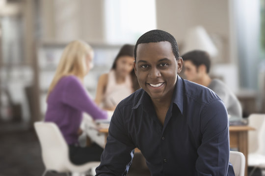 Smiling Black man studying with friends
