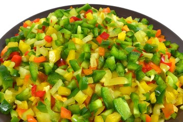 Finely chop flesh of five varieties colorful bell peppers lies in large platter, top view. Isolated on white background