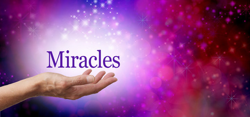 Asking for Miracles background - female hand facing up with the word MIRACLES floating in a white sparkling oval on a deep pink background with glittering sparkles and copy space to right side - obrazy, fototapety, plakaty