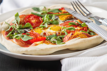 Home Italian pizza with tomato and quail eggs salad