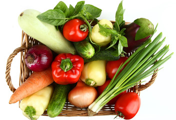 Wicker basket with vegetables on white isolated background