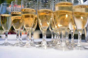 Beautiful wedding slide champagne for bride and groom indoors. Colorful glasses for alcohol with berries. Beauty of bridal interior for marriage. Bright bar for celebration