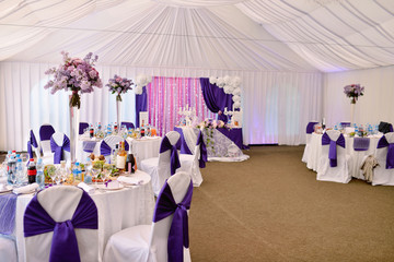 Beautiful wedding restaurant for marriage. White decor for bride and groom. Colorful decoration for celebration. Beauty bridal interior. Bouquet, food and flowers in hall