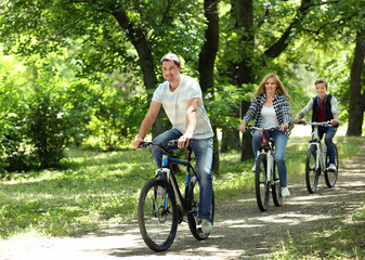 Fototapeta premium Happy family on bike ride in park